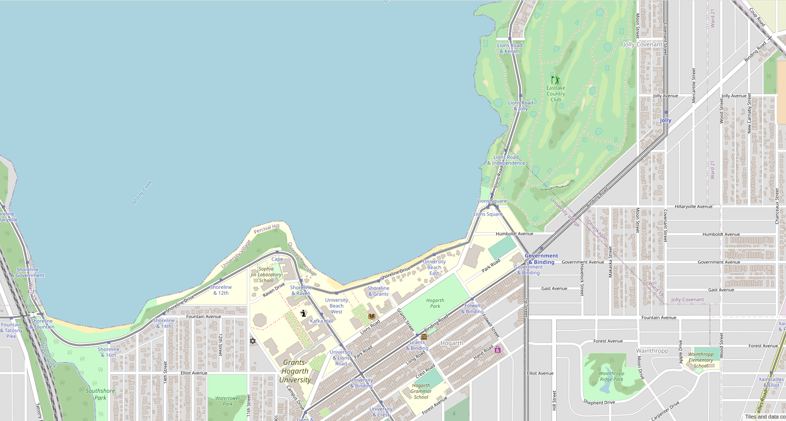 Screenshot of the map window on the OpenGeofiction site, showing an area mapped of an area around a lakeshore with lots of detail, including a university campus and a golf course