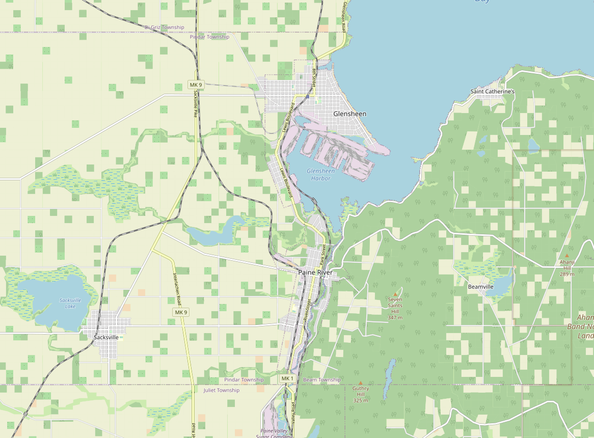 Screenshot of the map window on the OpenGeofiction site, a rural area with several medium-sized towns at the bay of a large lake and and river valley, with lots of detail